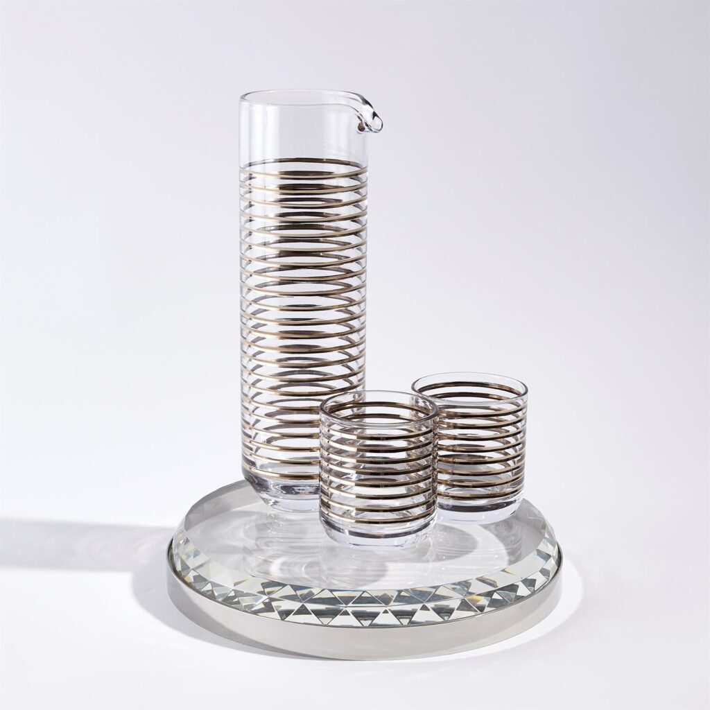A handmade glassware entertaining set, including a pitcher, two glasses and a tray, representing luxury items perfect for entertaining at home.