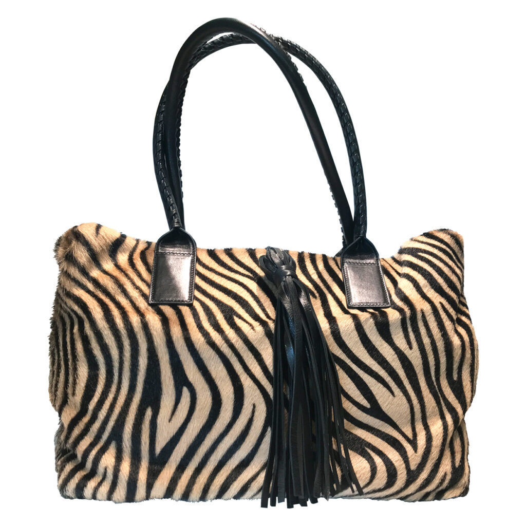 A zebra striped, large tote bag. Representing a large, vibrant collection of purses in a variety of finishes, shapes, and colors.