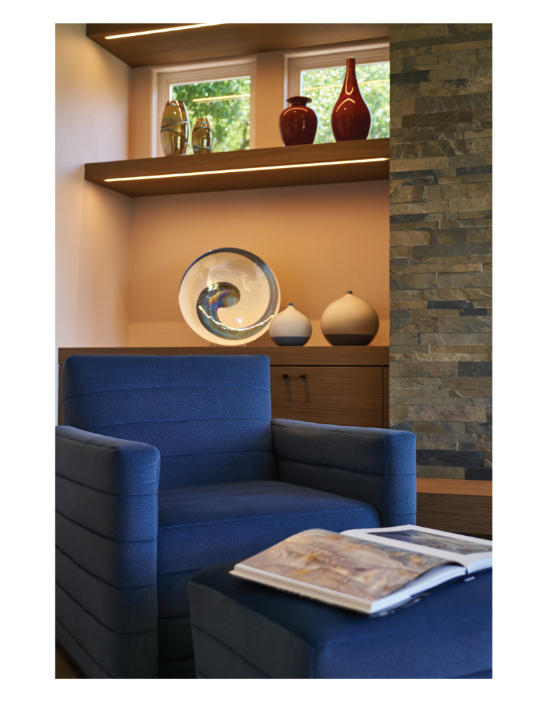 Luxury interior design for a home in Tiburon, California, in the San Francisco Bay Area, including custom designed and upholstered furniture by Ruth Livingston Designs. 

The room includes a custom designed and upholstered blue armchair with built-in shelving and handcrafted pottery and vases. 
