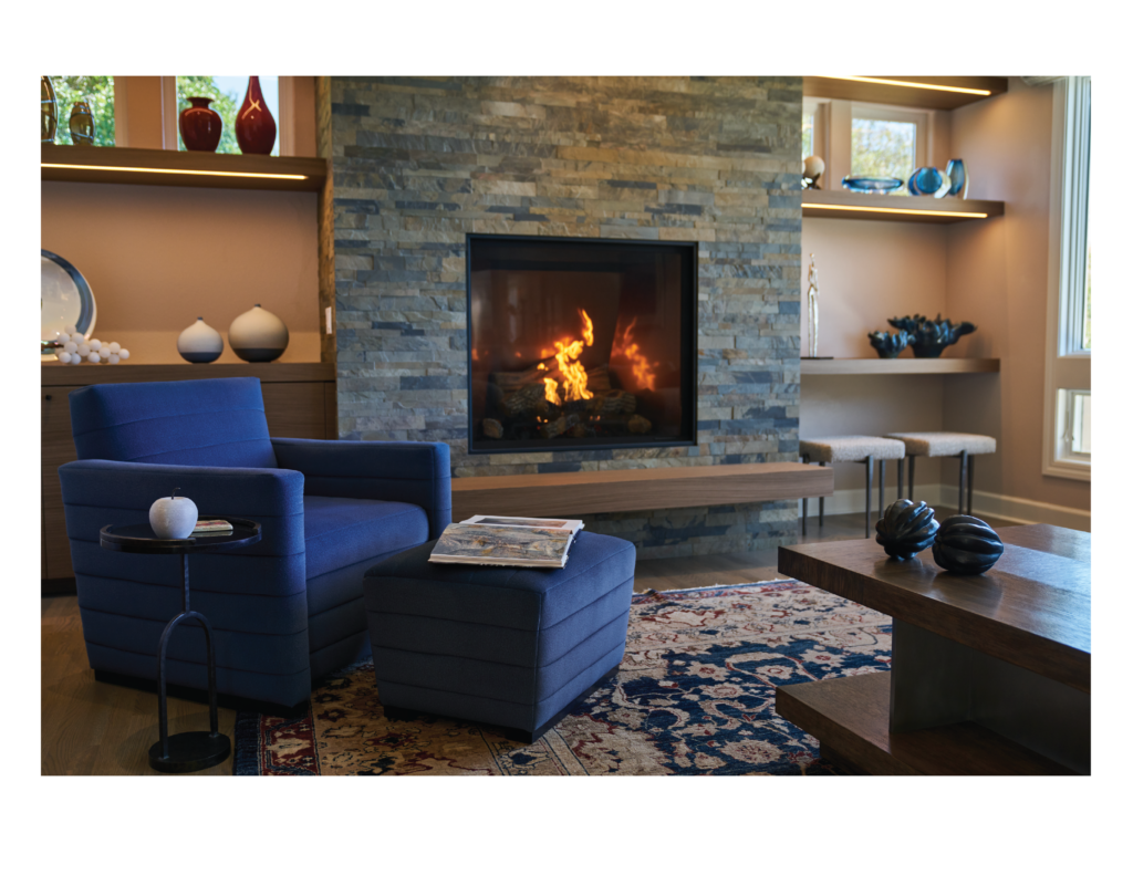 Luxury interior design for a home in Tiburon, California, in the San Francisco Bay Area, including custom designed and upholstered furniture by Ruth Livingston Designs. 

The room includes a custom designed and upholstered blue armchair and ottoman in a living room with a fireplace and a wood coffee table.